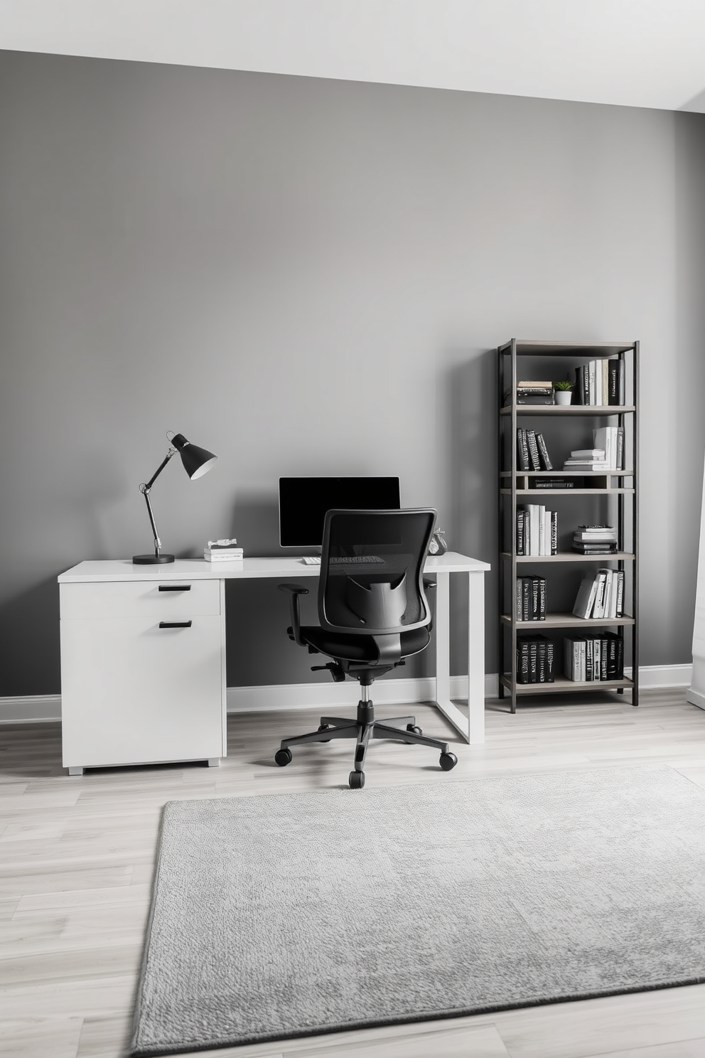 A serene home office setting featuring a sleek desk with clean lines and a comfortable ergonomic chair. The walls are painted in varying shades of gray, creating a cohesive and calming atmosphere. A minimalist bookshelf stands against one wall, filled with neatly arranged books and a few decorative items. A soft gray area rug anchors the space, adding warmth and texture to the monochromatic design.