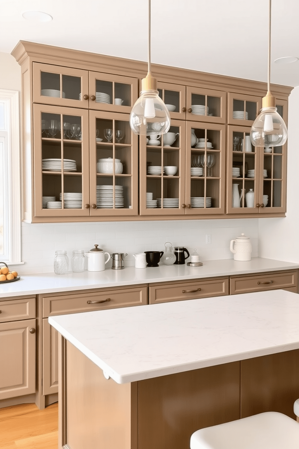 A simple kitchen design featuring glass-front cabinets for display. The cabinets are filled with neatly arranged dishware and glassware, creating an inviting and organized atmosphere. The kitchen island is topped with a light-colored quartz countertop, providing ample space for meal preparation. Soft pendant lights hang above the island, adding warmth and elegance to the overall design.