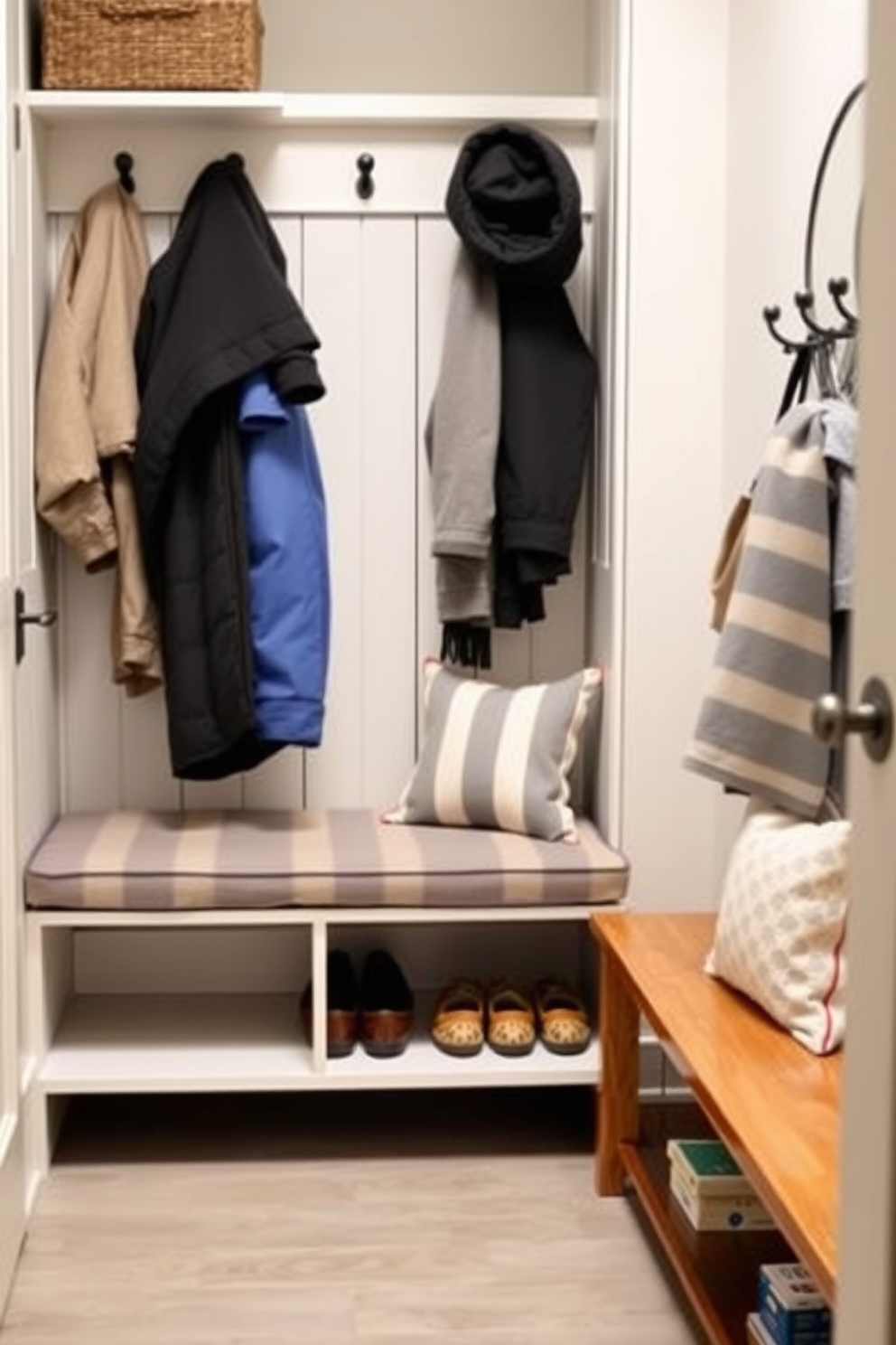 A mudroom features a stylish bench with removable cushions for added comfort. The space is organized with hooks for coats and a shelf for shoes, creating a functional and inviting entryway.