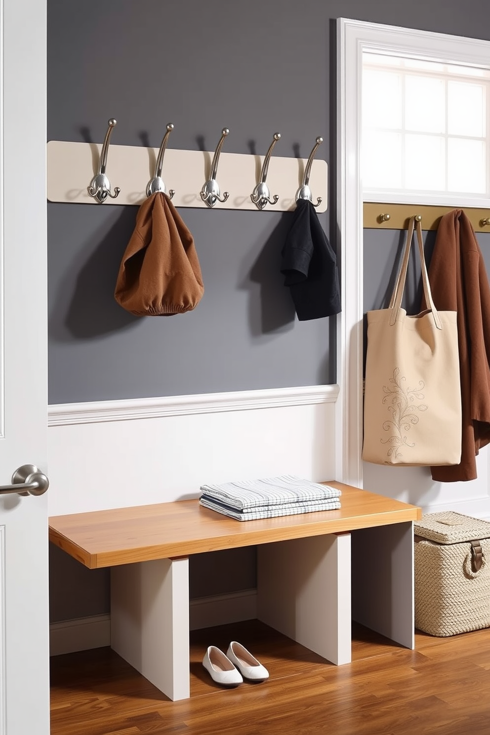 A stylish mudroom features a row of elegant wall hooks crafted from brushed nickel, perfect for hanging jackets and bags. The space is adorned with a warm wood bench beneath the hooks, providing a practical area for putting on shoes.