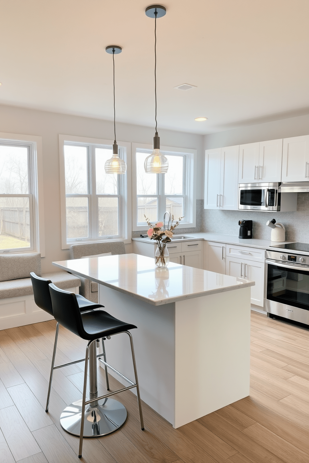 A cozy dining space features a sleek kitchen island with two modern bar stools positioned neatly on one side. The island is topped with a polished quartz surface, complemented by pendant lights hanging above, illuminating the space with a warm glow. The kitchen showcases a minimalist design with white cabinetry and stainless steel appliances, creating a clean and functional look. A subtle backsplash in soft gray adds texture, while large windows allow natural light to flood the area, enhancing the inviting atmosphere.