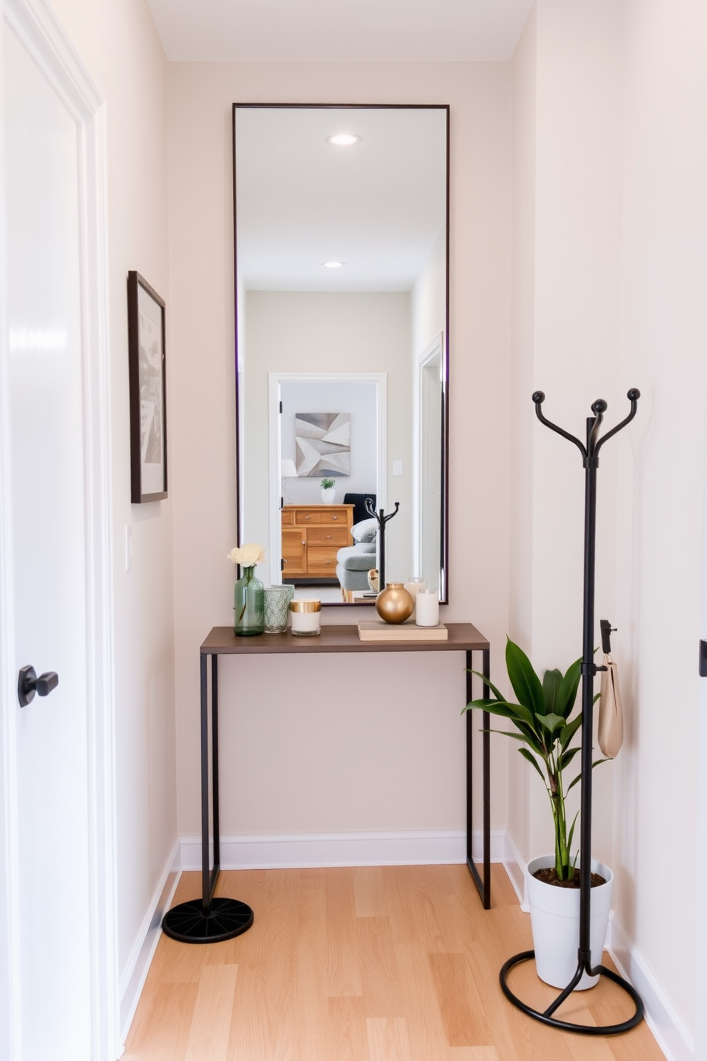 A small entryway features a large mirror that reflects light and creates an illusion of spaciousness. The walls are painted in a soft pastel hue, and a narrow console table adorned with decorative items sits beneath the mirror. The floor is finished with light-colored hardwood, adding warmth to the space. A stylish coat rack and a small potted plant complete the design, enhancing the entryway's functionality and aesthetic appeal.