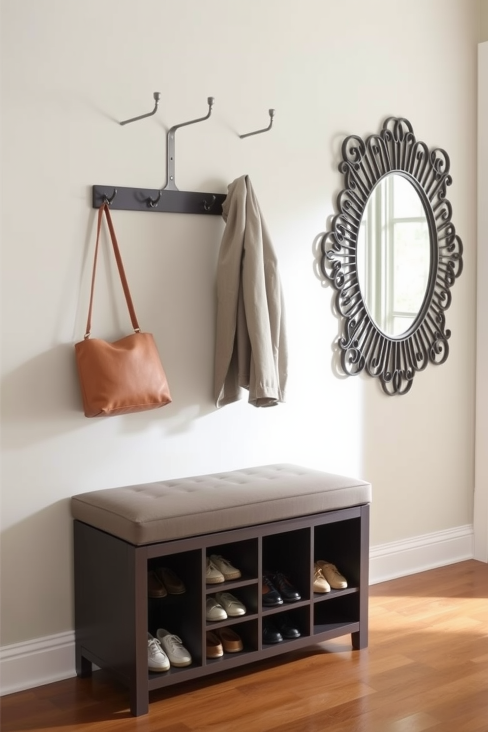 A stylish shoe storage bench is placed against the wall in a small entryway, offering both functionality and aesthetic appeal. The bench features a cushioned top for comfort and a series of cubbies underneath to neatly organize shoes. The walls are painted in a soft, welcoming hue, complemented by a sleek coat rack above the bench. A decorative mirror hangs nearby, enhancing the sense of space and reflecting natural light into the entryway.