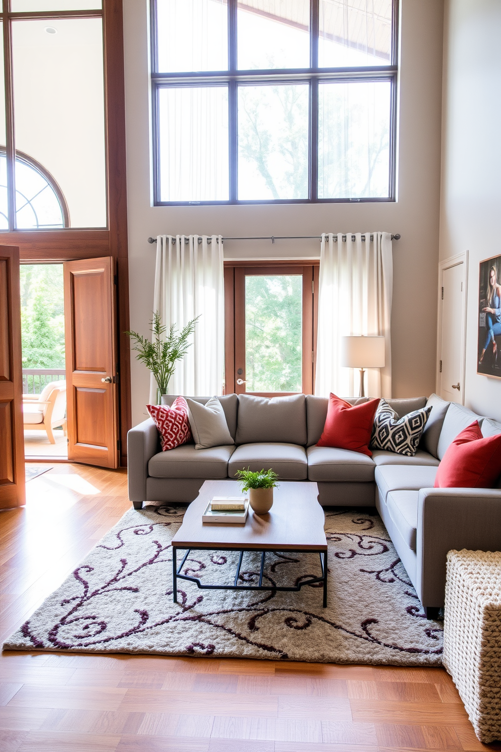 A cozy small family room featuring pocket doors that seamlessly blend into the walls. The room is filled with a comfortable sectional sofa in soft gray fabric, accented by colorful throw pillows. Natural light floods the space through large windows adorned with sheer white curtains. A stylish coffee table sits at the center, surrounded by a plush area rug that adds warmth to the hardwood floor.