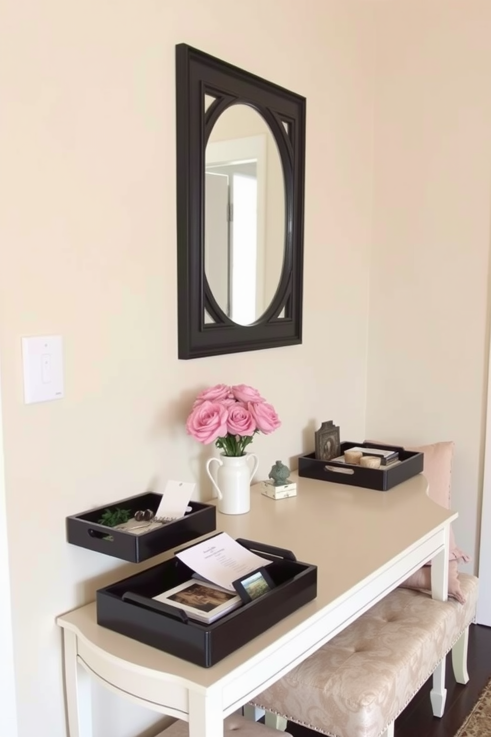 A small foyer designed for elegance and functionality. Decorative trays are used on a console table to organize keys, mail, and small accessories, creating a tidy and welcoming entrance. The walls are painted in a soft neutral tone, complemented by a stylish mirror that enhances the sense of space. A small bench with plush cushions sits against one wall, providing a cozy spot for putting on shoes while adding a touch of comfort.