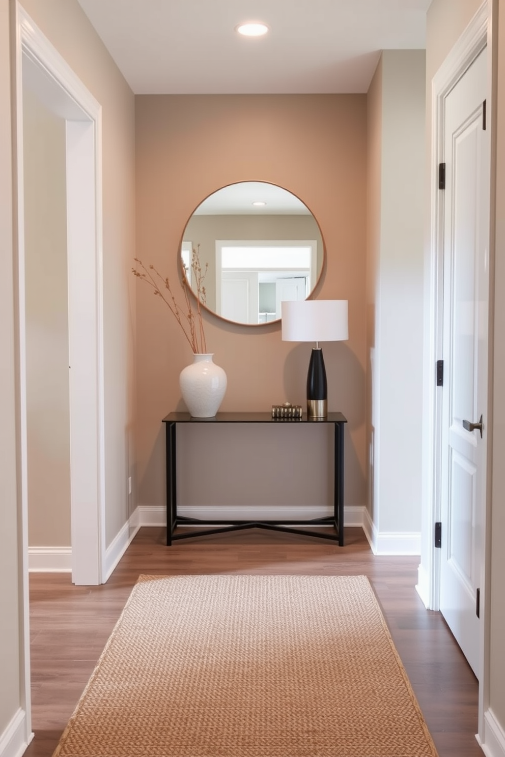 A small foyer designed with elegance and functionality. The space features a sleek console table against the wall, adorned with a decorative vase and a stylish lamp. A round mirror hangs above the table, reflecting light and creating a sense of openness. Soft neutral tones on the walls complement a textured area rug that adds warmth to the entryway.