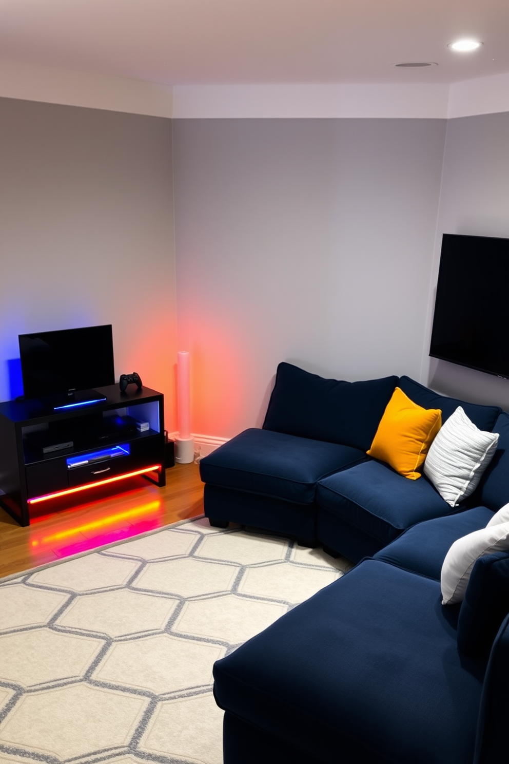 A cozy corner for console gaming features a plush sectional sofa in a deep navy blue, adorned with soft throw pillows in contrasting colors. A sleek, modern console table holds the gaming console and accessories, while ambient LED lights create a warm and inviting atmosphere. The walls are painted in a soft gray, providing a neutral backdrop that enhances the room's coziness. A large area rug in a geometric pattern anchors the space, and a wall-mounted TV is positioned for optimal viewing from the sofa.