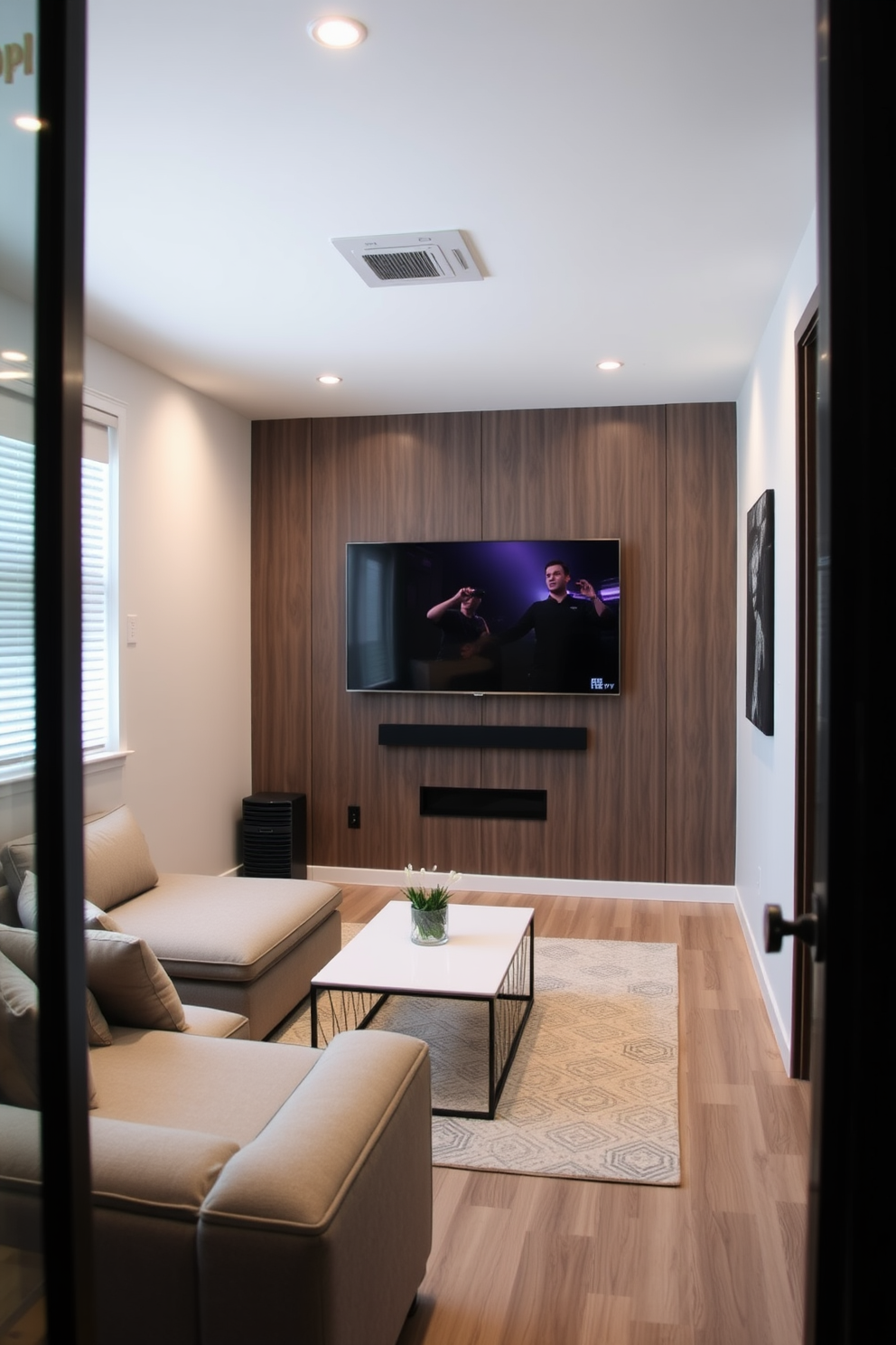 A small game room features a wall-mounted TV that maximizes floor space while providing an immersive viewing experience. The room is designed with a cozy sectional sofa and a sleek coffee table, creating an inviting atmosphere for relaxation and entertainment.