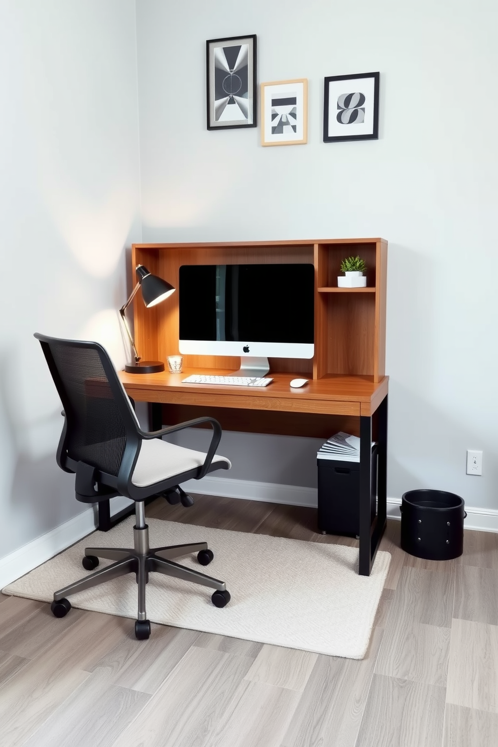 A cozy small home office setting. There's a sleek wooden desk positioned against the wall, complemented by a comfortable ergonomic chair and a stylish desk lamp. A soft area rug in a neutral tone is placed under the desk to define the workspace. The walls are painted in a light gray shade, and a few framed artworks hang above the desk, adding a personal touch.