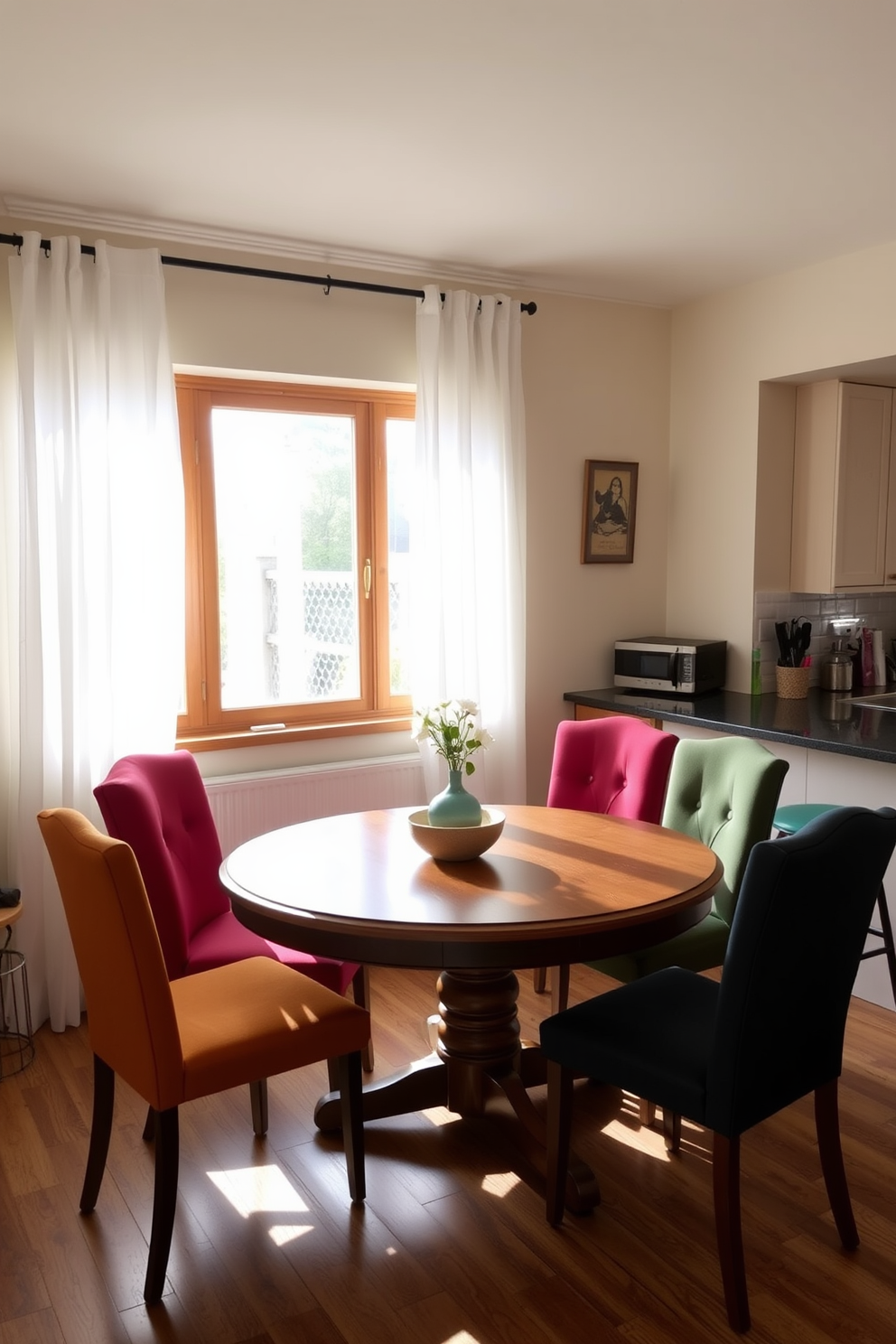 A cozy kitchen dining area featuring a round wooden table surrounded by vibrant, upholstered chairs in various colors. The walls are painted in a soft cream hue, and natural light streams in through a large window adorned with sheer white curtains.