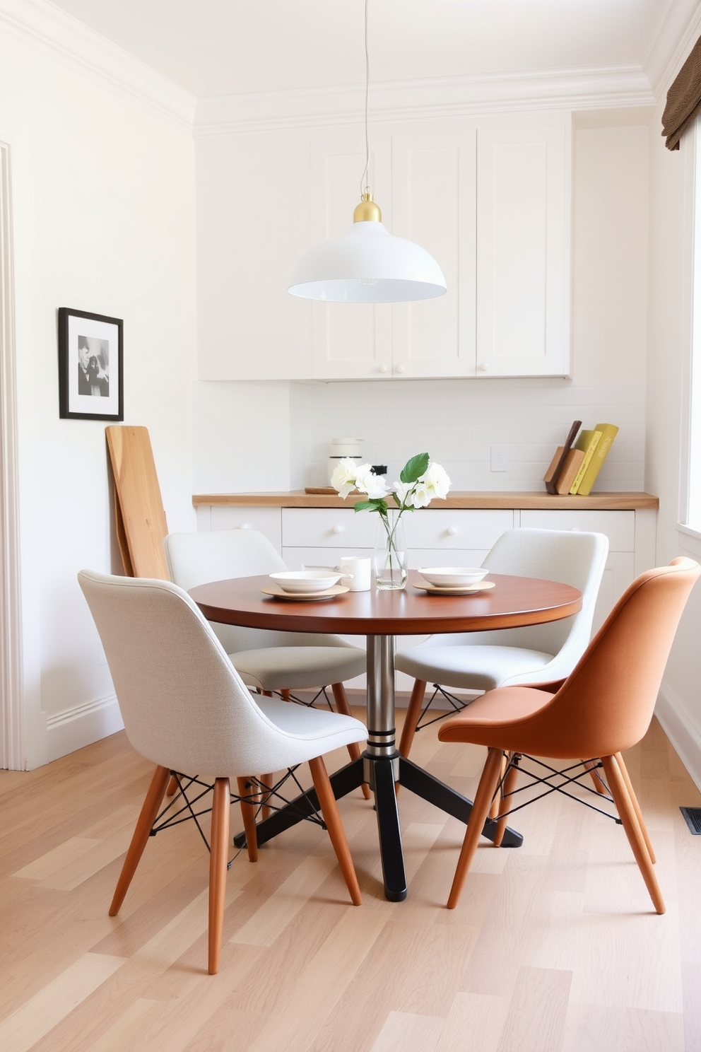 A cozy kitchen dining area featuring a round table that promotes easy movement and conversation. Surrounding the table are four stylish chairs in a light fabric, creating a warm and inviting atmosphere. The walls are painted in a soft pastel color, enhancing the brightness of the space. A simple pendant light hangs above the table, adding a touch of elegance to the room.