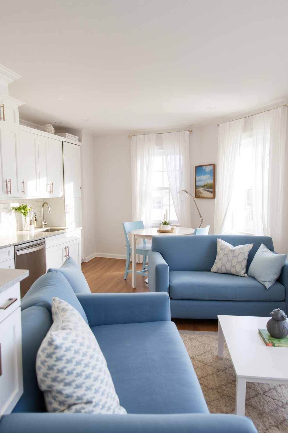 A cozy small kitchen living room design featuring a cohesive color palette of soft blues and warm whites. The kitchen area includes sleek white cabinetry with brushed nickel handles and a compact island topped with a light gray quartz surface. In the living room space, a plush blue sofa is paired with a white coffee table and accent pillows that complement the kitchen colors. Natural light floods the room through large windows adorned with sheer white curtains, enhancing the airy and inviting atmosphere.