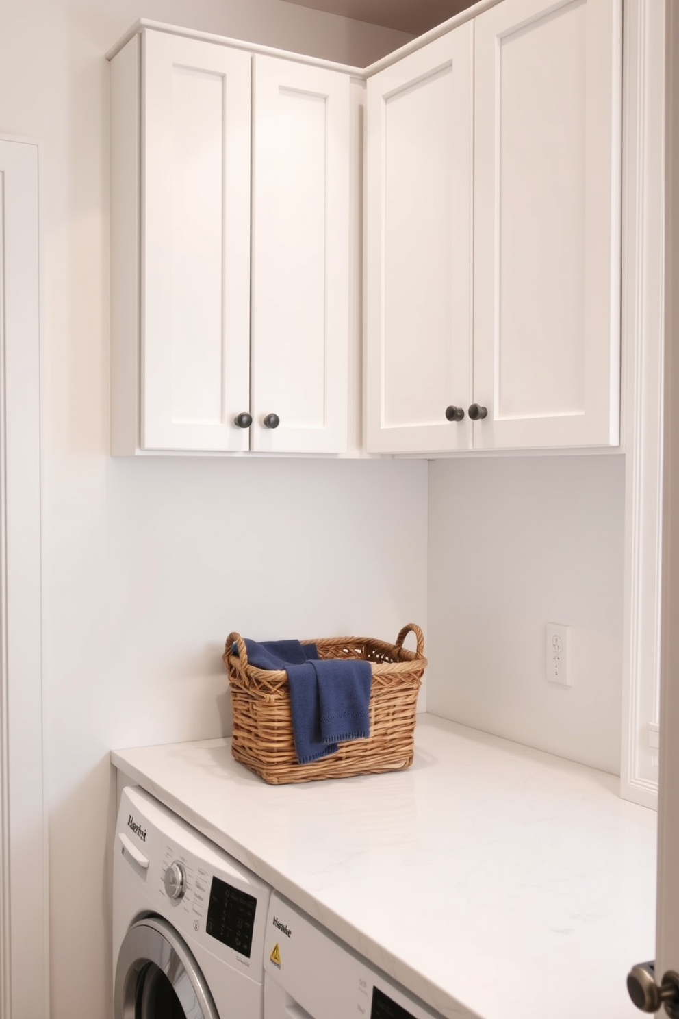 A small laundry room design featuring wall-mounted cabinets for efficient storage. The cabinets are painted in a soft white hue, creating a clean and airy feel in the space. The countertop is made of sleek quartz, providing ample space for folding clothes. A stylish basket sits on the countertop, adding a touch of warmth to the minimalist design.