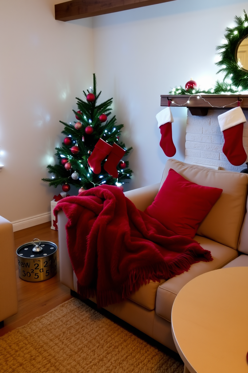 A cozy small living room decorated for Christmas. A plush red throw blanket is draped over a neutral-colored sofa, and a vibrant red pillow adds a festive touch. A small Christmas tree adorned with red ornaments stands in the corner. Stockings in various shades of red are hung from a rustic mantel, complemented by twinkling fairy lights.