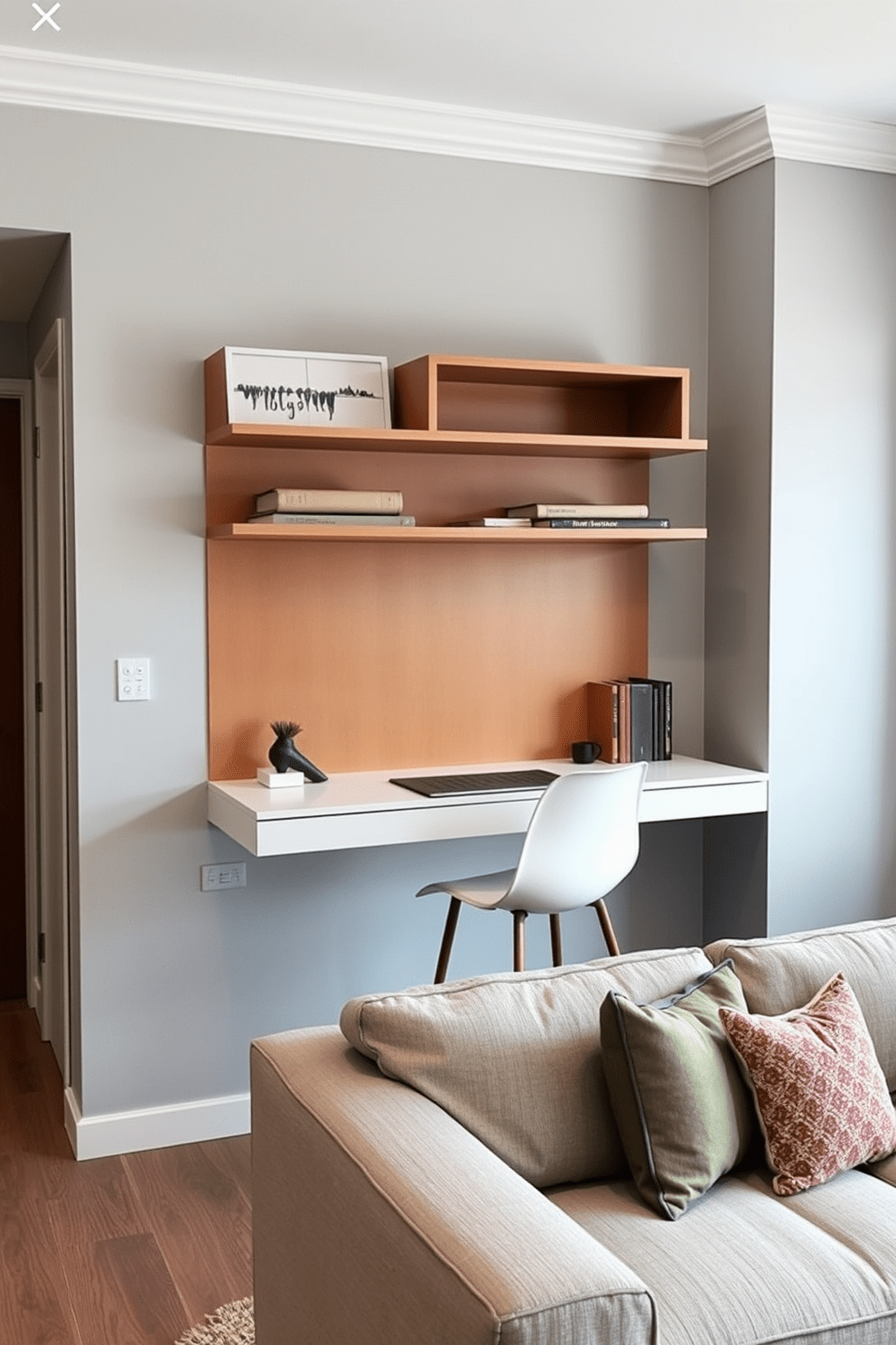 A small living room features a sleek wall-mounted desk that maximizes workspace efficiency. The desk is complemented by a comfortable chair and stylish shelves above, creating an organized and inviting atmosphere. The walls are painted in a soft gray, enhancing the room's brightness and spacious feel. A cozy area rug anchors the space, while decorative cushions on a minimalist sofa add a touch of color and comfort.