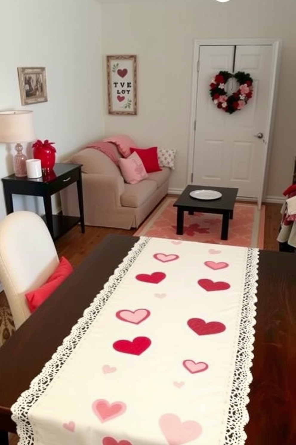 Chic table runner adorned with Valentine motifs drapes elegantly over a beautifully set dining table. The runner features heart patterns in soft pink and red, complemented by delicate white lace trim for a romantic touch. In a small living room, cozy accents enhance the Valentine's Day theme. Plush throw pillows in varying shades of red and pink are arranged on a neutral sofa, while a heart-shaped wreath hangs on the door to welcome guests.