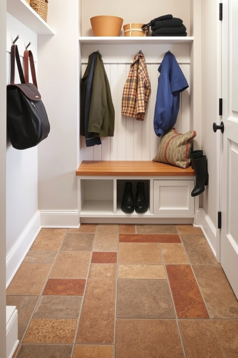 A small mudroom features rugged flooring designed for durability, showcasing a blend of textured tiles and natural stone. The space includes a built-in bench with storage below, complemented by hooks for coats and a small shelf for shoes.