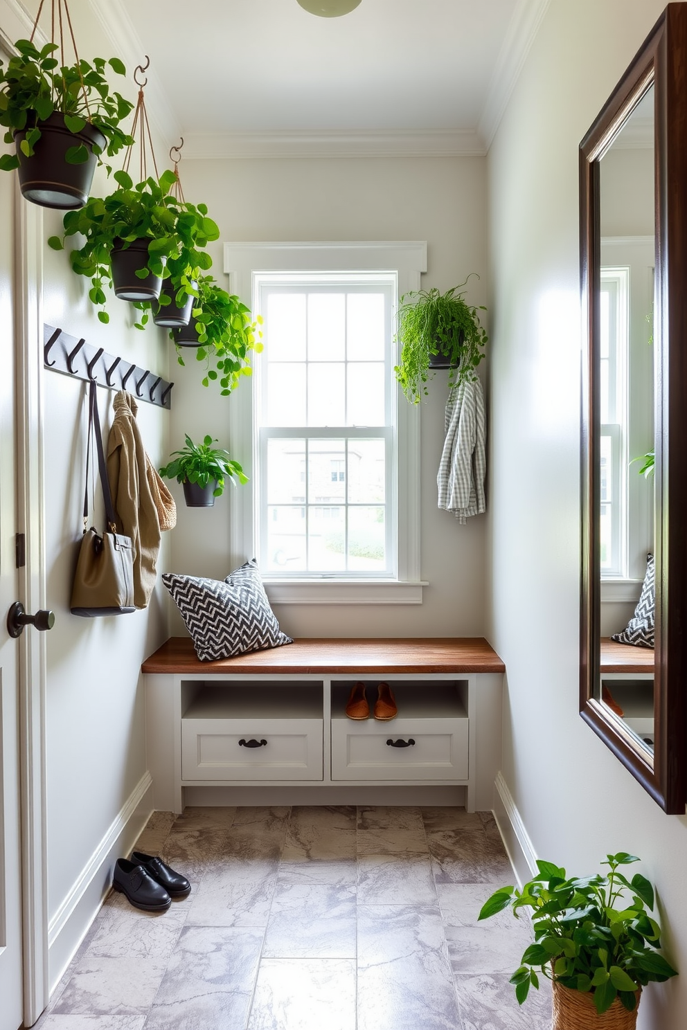 Hanging planters filled with lush green plants create a vibrant touch in a small mudroom. The walls are painted in a soft, welcoming color, and the floor features durable, textured tiles for added interest. A built-in bench with storage underneath provides a practical seating area for putting on shoes. Hooks above the bench hold coats and bags, while a large mirror reflects the natural light coming in from the nearby window.