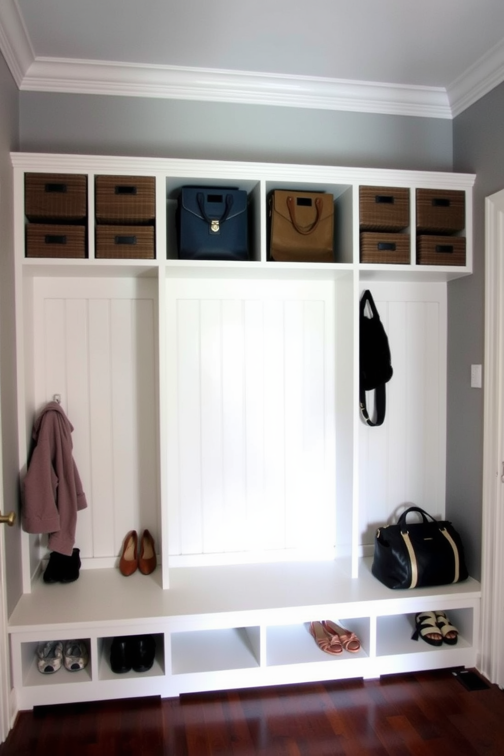 A cozy mudroom featuring cubbies for sorting shoes and bags. The walls are painted in a soft gray with white trim, and a bench sits beneath the cubbies for easy seating.