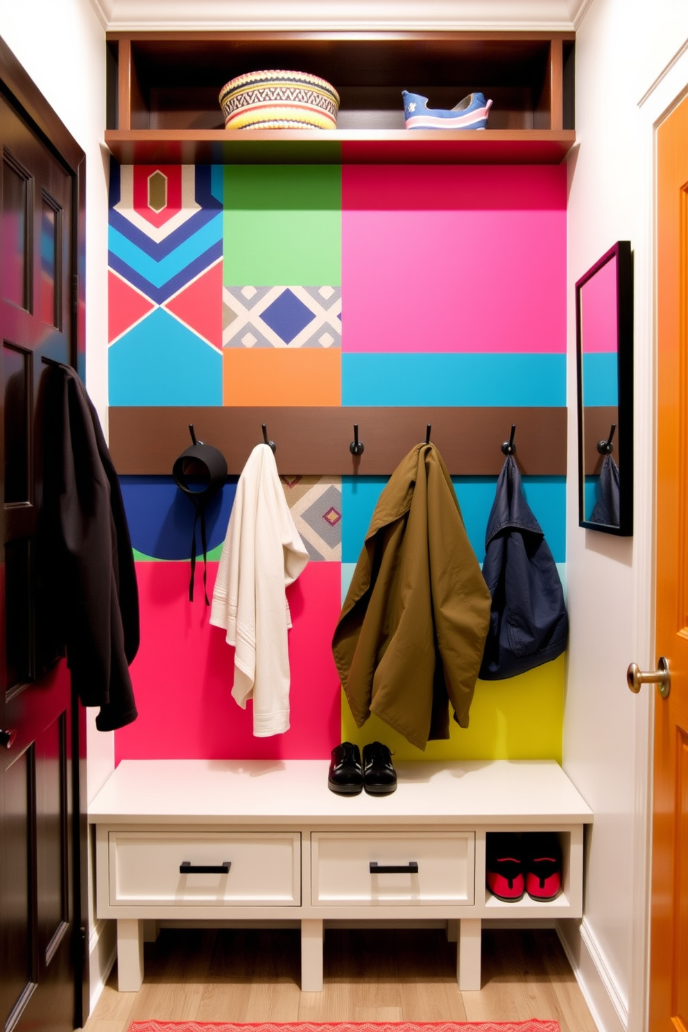 A colorful accent wall featuring bold geometric patterns and vibrant hues creates a lively focal point in the room. The wall is complemented by a minimalist bench and hooks for coats, enhancing functionality while adding a touch of personality. The small mudroom is designed with practical storage solutions, including a built-in cubby for shoes and a narrow shelf above for hats and gloves. Soft lighting and a cheerful color palette make the space inviting and organized, perfect for welcoming guests.