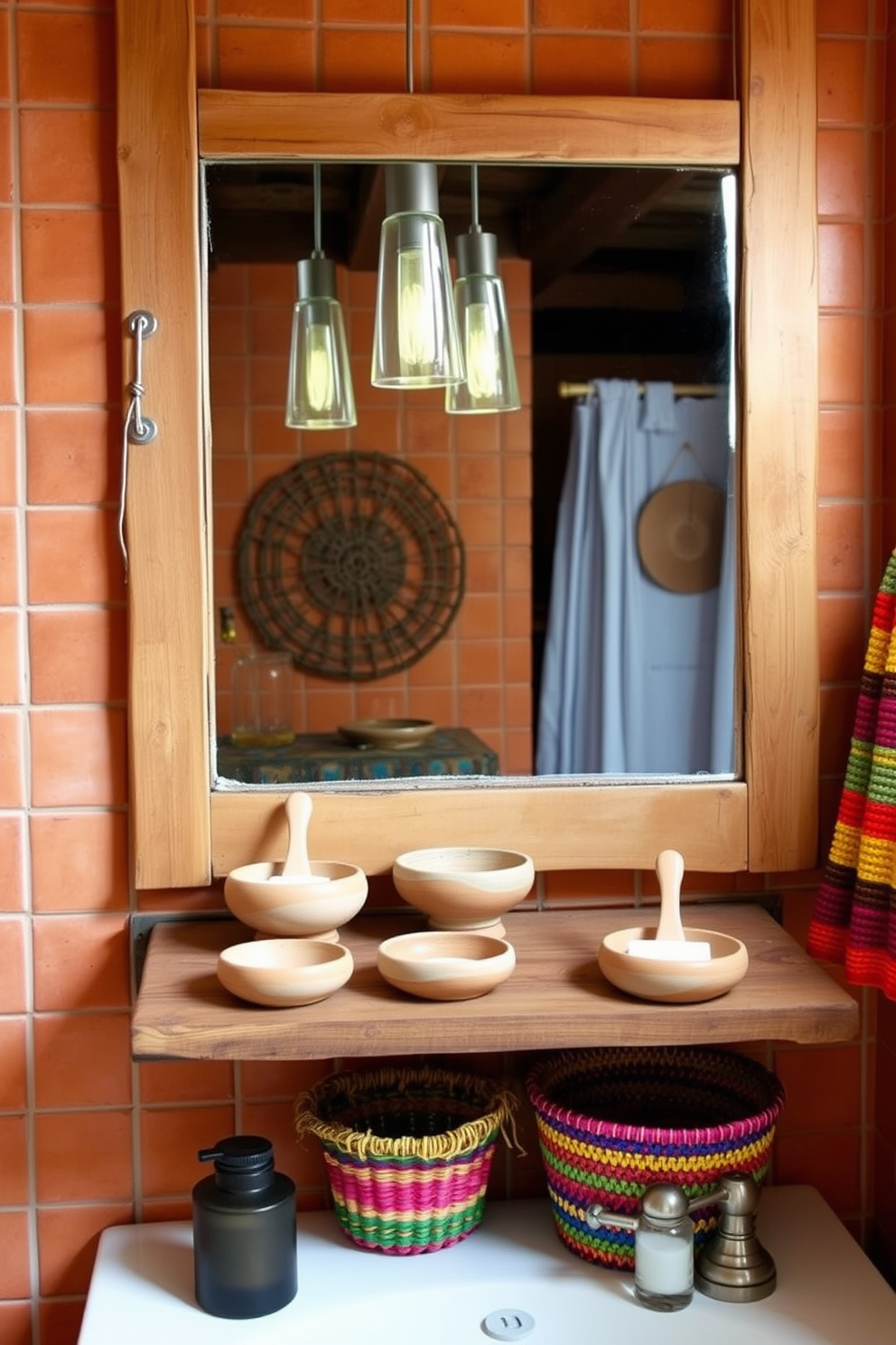 Handmade soap dishes crafted from natural clay are displayed on a rustic wooden shelf. The bathroom features warm earth tones with terracotta tiles and wooden accents, creating a cozy Southwestern atmosphere. Colorful woven baskets are used for storage, adding texture and charm to the space. A large mirror with a distressed wooden frame reflects the vibrant decor and the soft glow of pendant lights.