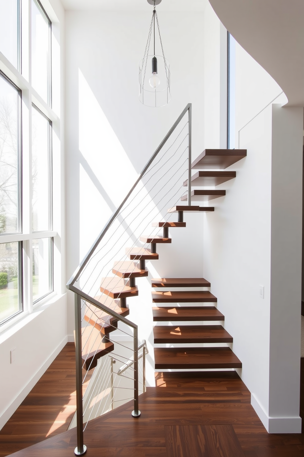 A unique staircase with an asymmetrical design features a combination of floating steps and a sleek metal railing. The steps are crafted from rich walnut wood, creating a striking contrast against the minimalist white walls. Natural light floods the space through large windows, highlighting the staircase's innovative angles and shapes. A contemporary pendant light hangs above, adding a touch of elegance to the modern aesthetic.