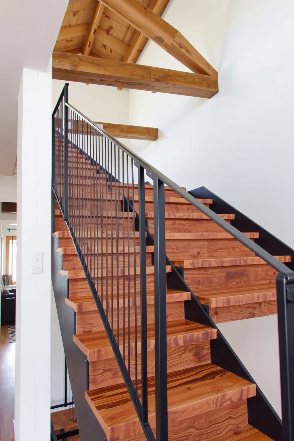 An industrial style staircase features open risers made of reclaimed wood, complemented by a sleek metal railing. Exposed beams run along the ceiling, adding character and a raw aesthetic to the overall design.