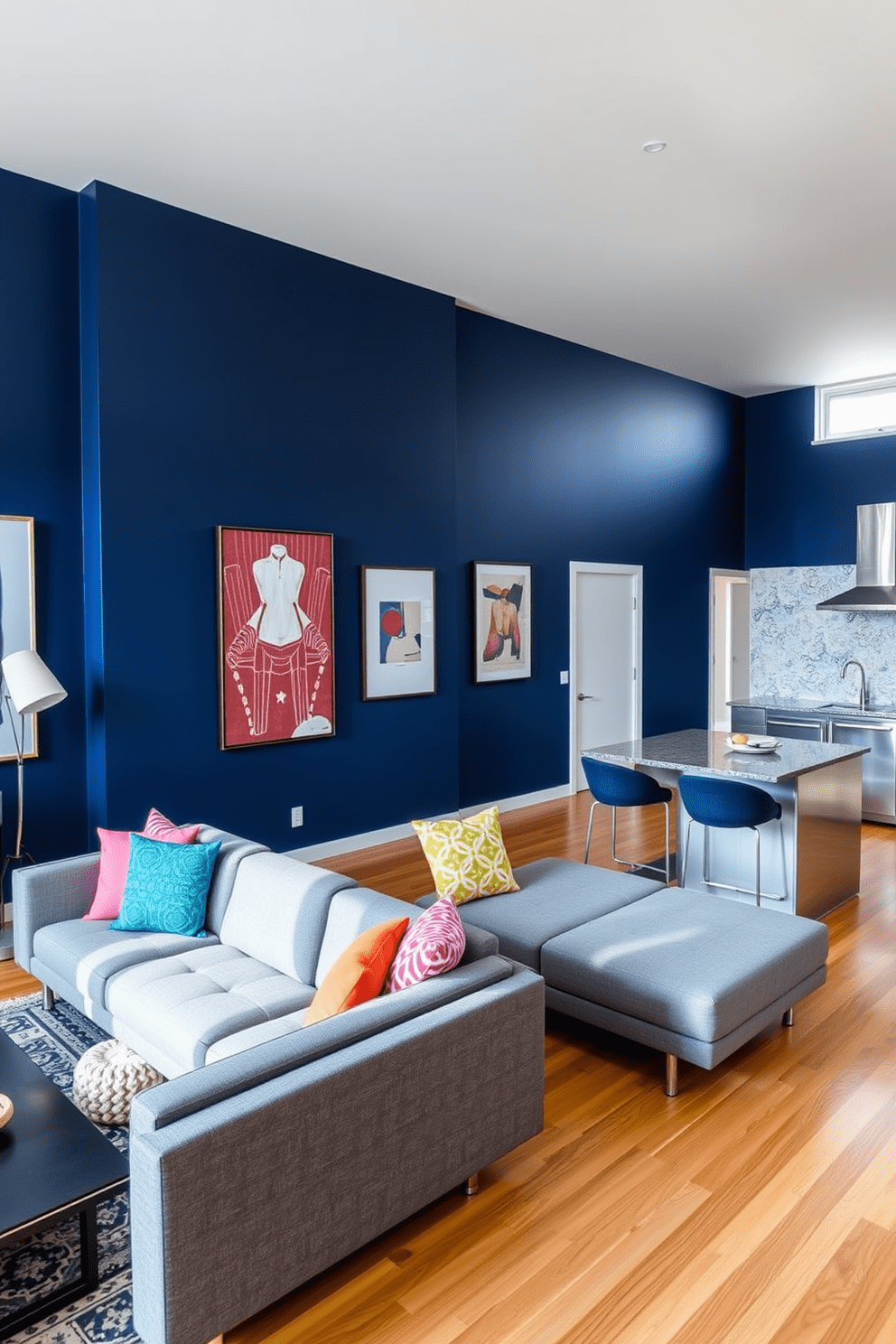 A stylish apartment features a statement wall painted in a bold navy blue, creating a striking focal point in the living area. The room is furnished with a sleek gray sofa, complemented by colorful throw pillows that add a pop of vibrancy to the space. The open-plan layout includes a modern kitchen with stainless steel appliances and a chic breakfast bar. Natural light floods the area through large windows, enhancing the warm wood tones of the flooring and the contemporary art pieces displayed on the walls.