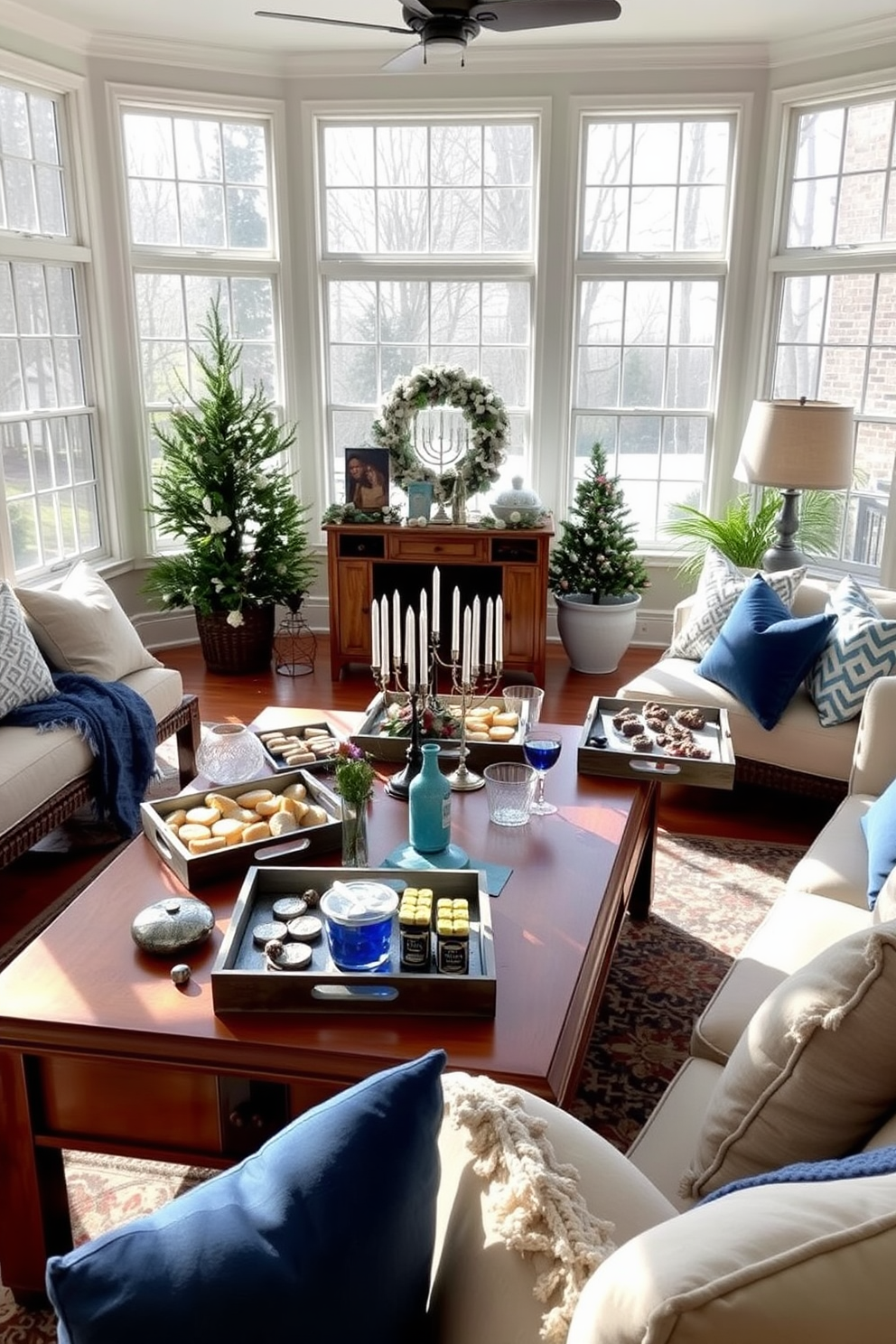 A bright and inviting sunroom filled with natural light. Decorative trays are elegantly arranged on a large wooden coffee table, showcasing an assortment of festive snacks and drinks. The space is adorned with Hanukkah decorations, including blue and silver accents throughout. Cozy seating is complemented by soft throw pillows, creating a warm atmosphere for gatherings.