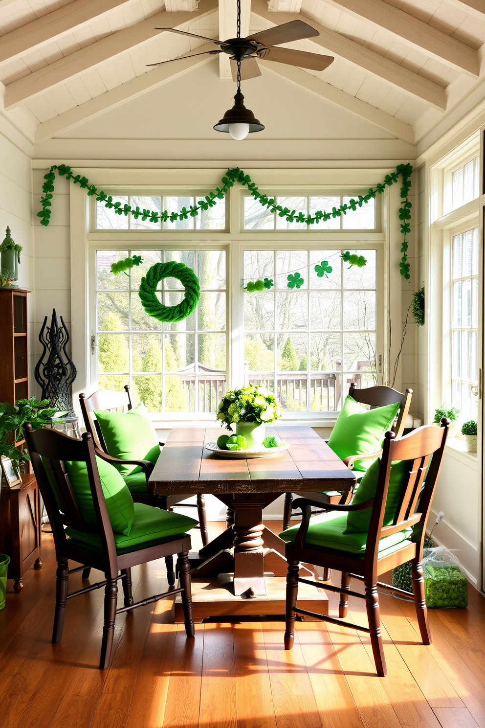 Mismatched chairs with green cushions are arranged around a rustic wooden table in a sunroom filled with natural light. The vibrant cushions add a festive touch, perfectly complementing the St. Patrick's Day decorations that include shamrock garlands and green accents throughout the space.