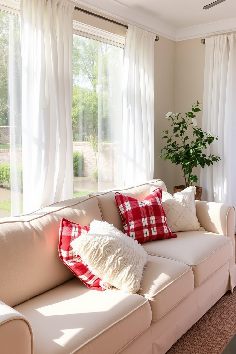 Cozy red and white throw pillows are arranged on a plush beige sofa in the sunroom. The sunroom is filled with natural light, and the walls are adorned with soft white curtains that gently flutter with the breeze.