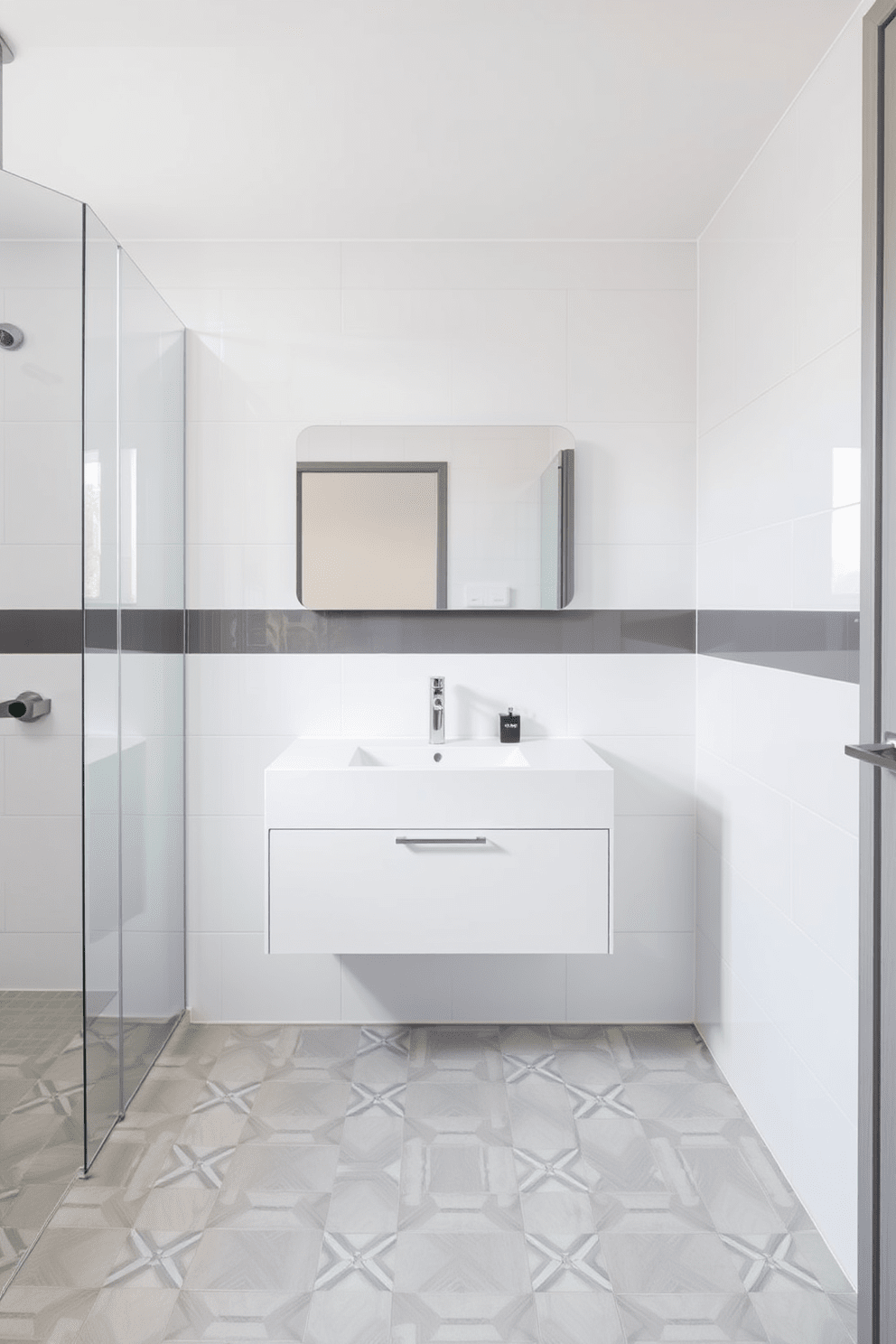 A modern minimalist three-quarter bathroom featuring sleek tile accents. The walls are adorned with large format white tiles, while the floor showcases a subtle geometric pattern in soft gray tones. A floating vanity with a simple, clean design is positioned against the wall. Above it, a frameless mirror reflects the natural light coming from a nearby window.