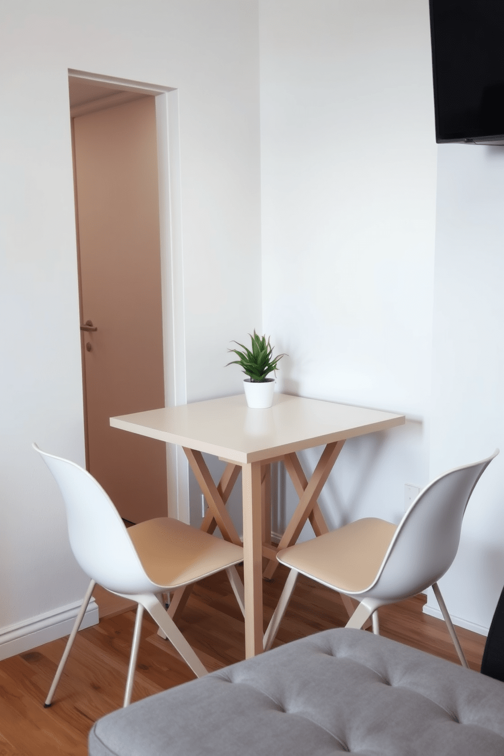 A cozy dining area in a tiny apartment featuring a foldable table that can be easily stored away when not in use. Surrounding the table are sleek, modern chairs that complement the minimalist aesthetic of the space. The walls are painted in a light, airy color to enhance the sense of openness. A small potted plant sits in the corner, adding a touch of greenery and warmth to the compact design.