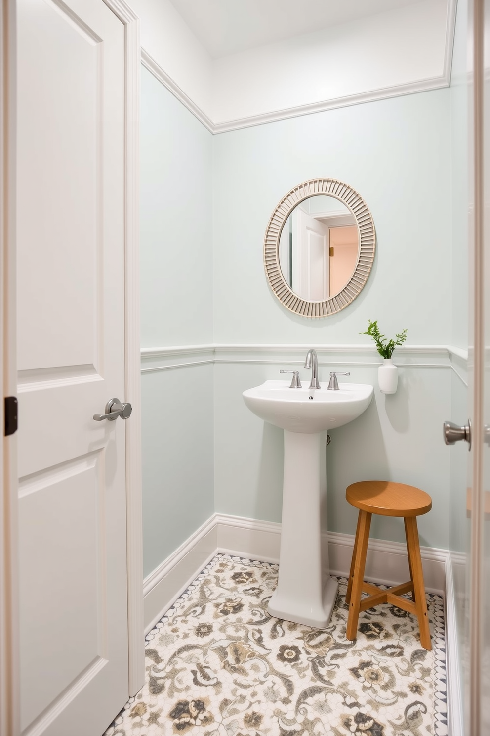 A chic powder room with a compact layout. The walls are painted in a soft pastel hue, and a sleek pedestal sink is positioned against one wall. To the right of the sink, a small wooden stool adds convenience and style. The floor is adorned with elegant mosaic tiles, and a round mirror with a decorative frame hangs above the sink.