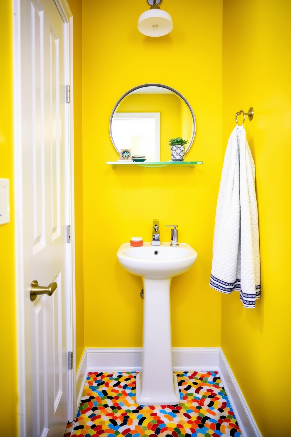 A bright and cheerful tiny powder room features walls painted in a vibrant yellow hue that instantly lifts the mood. The space includes a compact white pedestal sink with a sleek chrome faucet and a round mirror framed in polished silver above it. To maximize the small area, a floating shelf holds decorative items and a small potted plant. The floor is adorned with colorful mosaic tiles that add a playful touch, while a stylish hand towel hangs neatly from a wall-mounted rack.