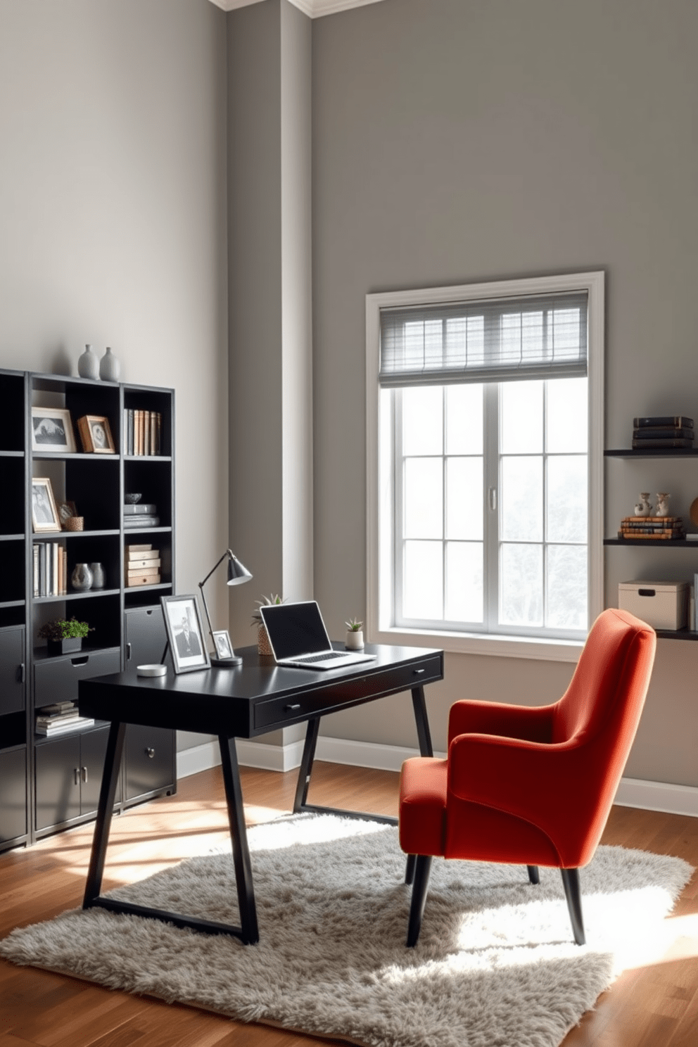 A stylish home office space features a sleek black desk positioned against a large window that lets in ample natural light. The walls are painted a soft gray, complemented by a cozy armchair in a bold color, adding a pop of personality to the room. On the desk, a modern laptop sits alongside a stylish desk lamp and a few decorative items like a small plant and framed photos. The floor is adorned with a plush area rug, and shelves filled with books and decorative boxes line the wall, creating an organized yet inviting atmosphere.