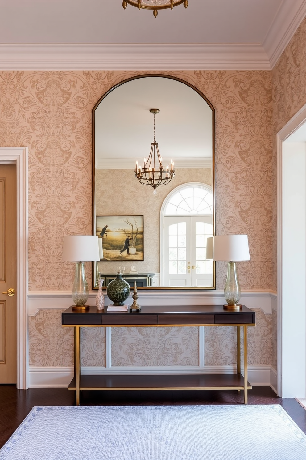 A spacious townhouse entryway features a large mirror that reflects natural light, creating an inviting atmosphere. The walls are adorned with elegant wallpaper in soft neutral tones, and a stylish console table sits beneath the mirror, topped with decorative accents.