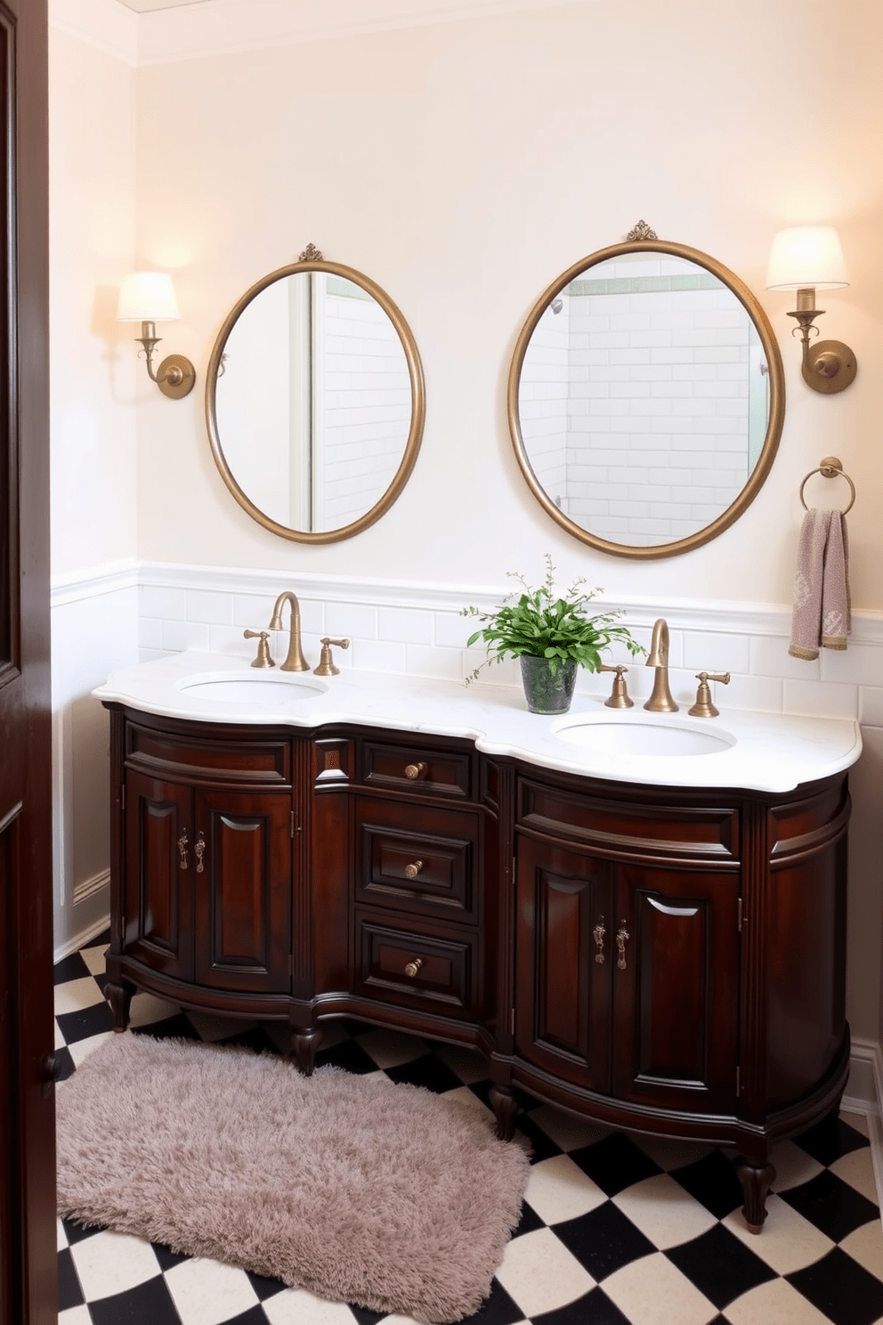 A traditional bathroom setting featuring a double vanity with vintage charm. The vanity is crafted from dark wood with ornate detailing and topped with a polished white marble surface. Above the vanity, two round mirrors with antique gold frames are mounted on the wall. The walls are painted in a soft cream color, complemented by classic white subway tiles that line the shower area. Elegant sconces with warm lighting flank the mirrors, creating a cozy atmosphere. The floor is covered with a timeless black and white checkerboard tile, adding a touch of sophistication. A plush area rug in muted tones lies beneath the vanity, enhancing the warmth of the space. Fresh greenery in a decorative pot sits on the countertop, bringing a hint of nature indoors.