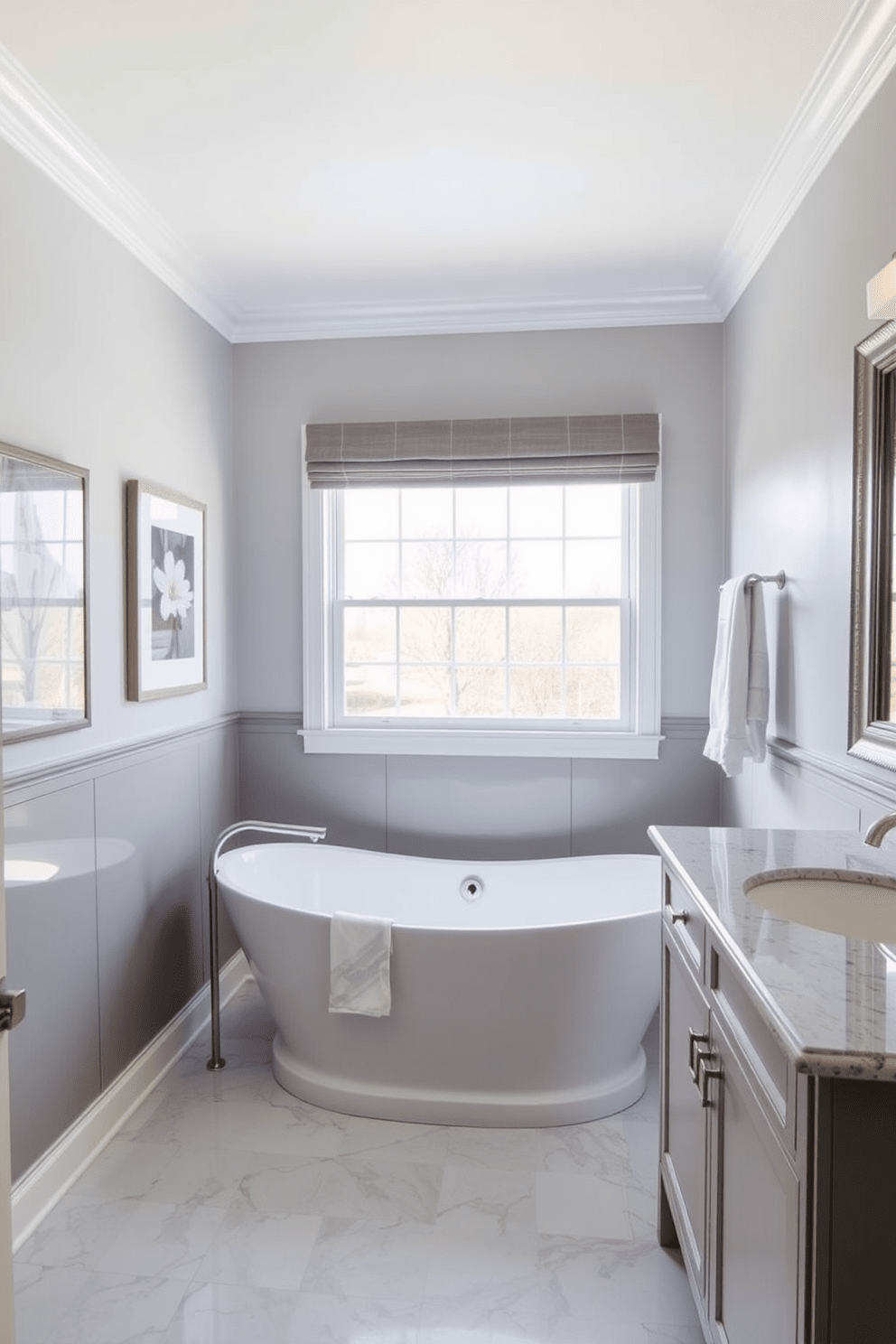 A stylish transitional bathroom features a freestanding soaking tub positioned under a large window that allows natural light to flood the space. The walls are adorned with decorative artwork that complements the soft gray and white color palette, creating a serene atmosphere. The vanity showcases a blend of classic and modern elements with a quartz countertop and brushed nickel fixtures. Above the vanity, a framed piece of artwork adds a personal touch, harmonizing with the overall design aesthetic.