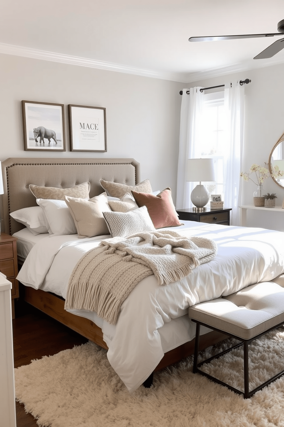 A cozy transitional bedroom featuring layered textures and plush bedding options. The bed is dressed in a combination of soft linens, a chunky knit throw, and an array of decorative pillows in neutral tones. Natural light floods the room through sheer curtains, highlighting a warm wooden bed frame and a stylish upholstered headboard. A plush area rug anchors the space, while a mix of modern and vintage furniture pieces add character and charm.