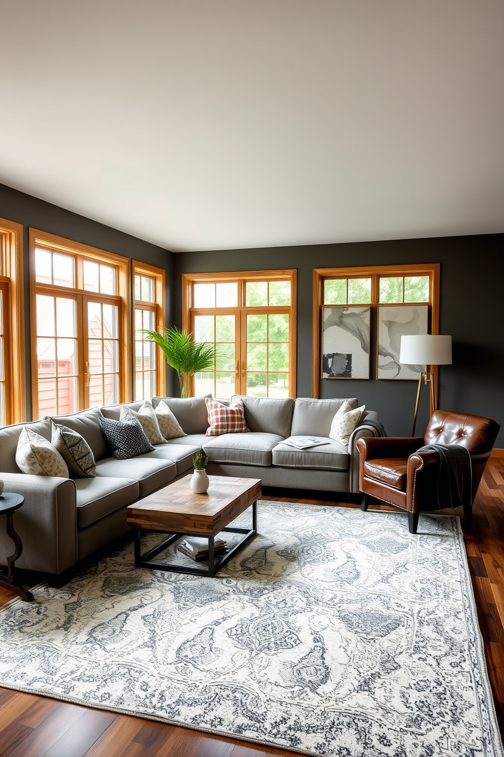 A transitional living room that blends contemporary and traditional styles. The space features a plush sectional sofa in a soft gray fabric paired with a vintage leather armchair, creating a harmonious mix of textures. A large area rug anchors the seating arrangement, while a sleek coffee table made of reclaimed wood adds warmth. Floor-to-ceiling windows allow natural light to flood the room, highlighting decorative pillows in various patterns and colors.