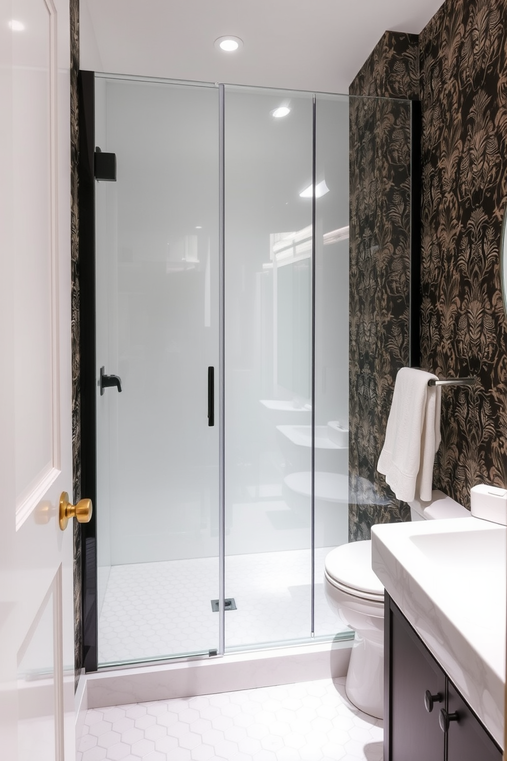 A trendy powder room featuring a glass shower enclosure that enhances the open feel of the space. The walls are adorned with bold wallpaper, and the floor showcases stylish hexagonal tiles.