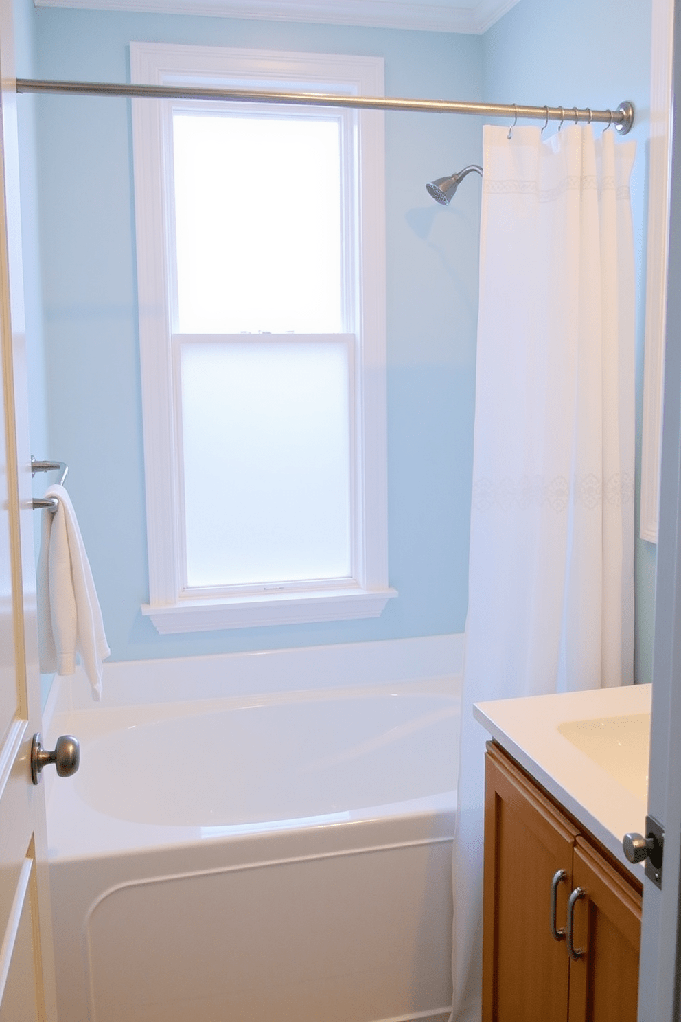 A serene bathroom featuring a tub shower combo with a cohesive color scheme that blends soft blues and whites. The walls are painted in a calming light blue, while the shower curtain complements the palette with subtle patterns. The tub is elegantly positioned under a frosted window, allowing natural light to filter in. A sleek, modern faucet and fixtures in brushed nickel add a touch of sophistication to the design.