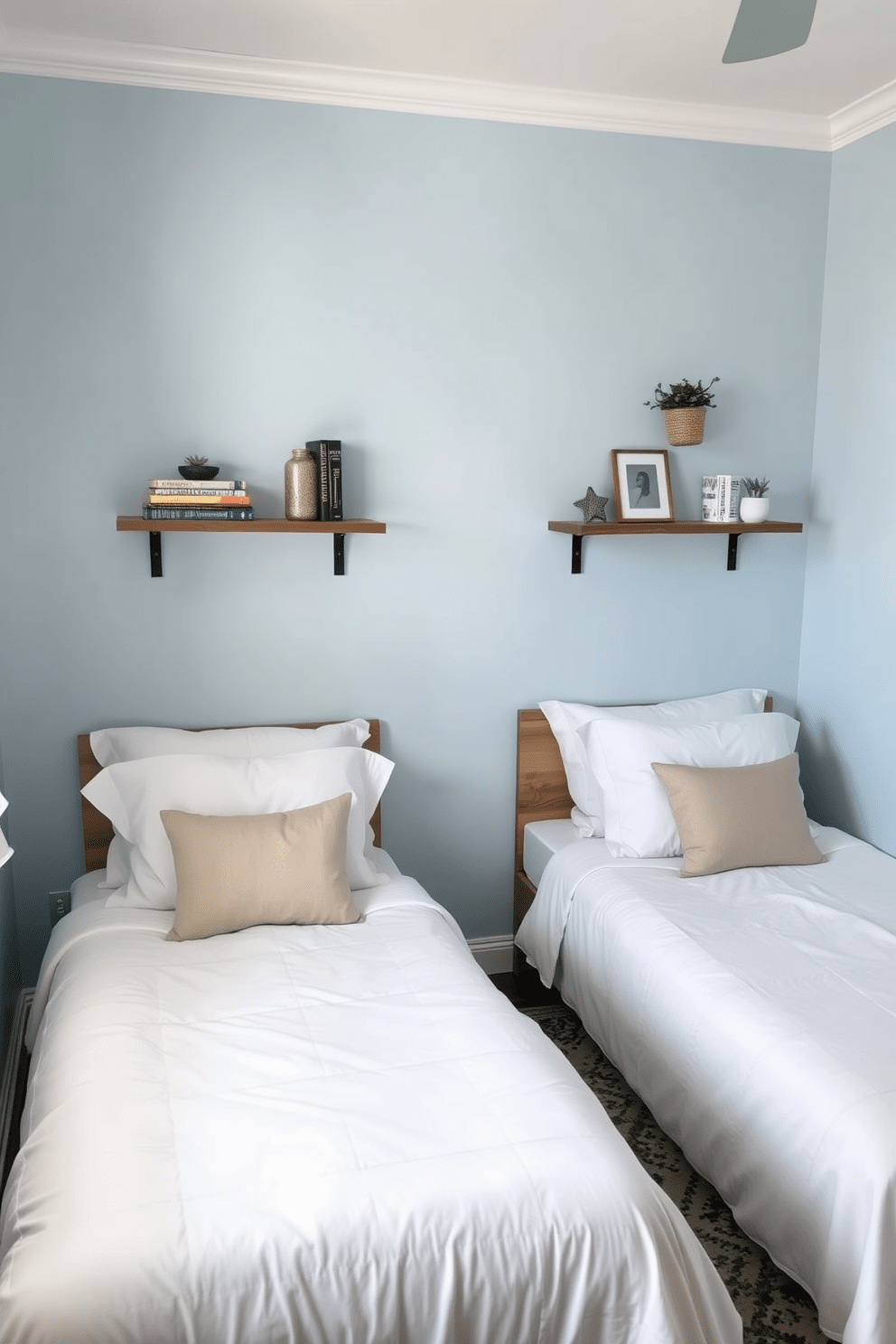 A cozy twin bedroom featuring two beds with soft white linens and plush pillows. Floating shelves are mounted above each bed, adorned with decorative books and small plants for a personalized touch. The walls are painted in a soothing light blue hue, creating a calm atmosphere. A stylish area rug lies beneath the beds, adding warmth and texture to the space.