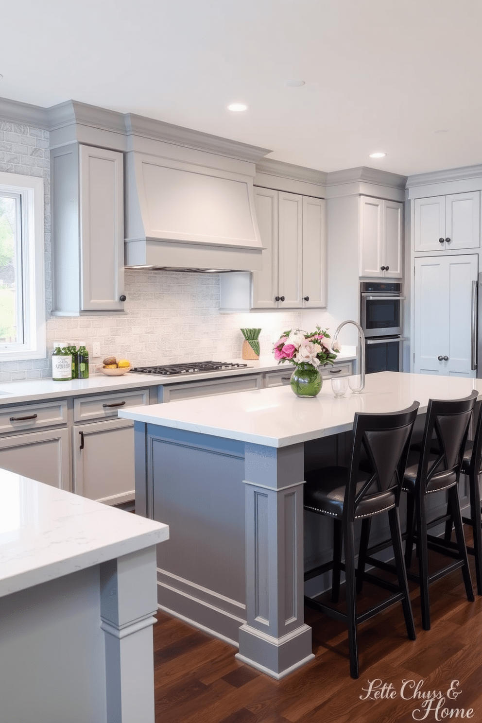 A two tone kitchen design featuring soft gray cabinets and crisp white upper cabinetry. The kitchen includes a large island with a white quartz countertop and stylish bar stools that invite casual dining.