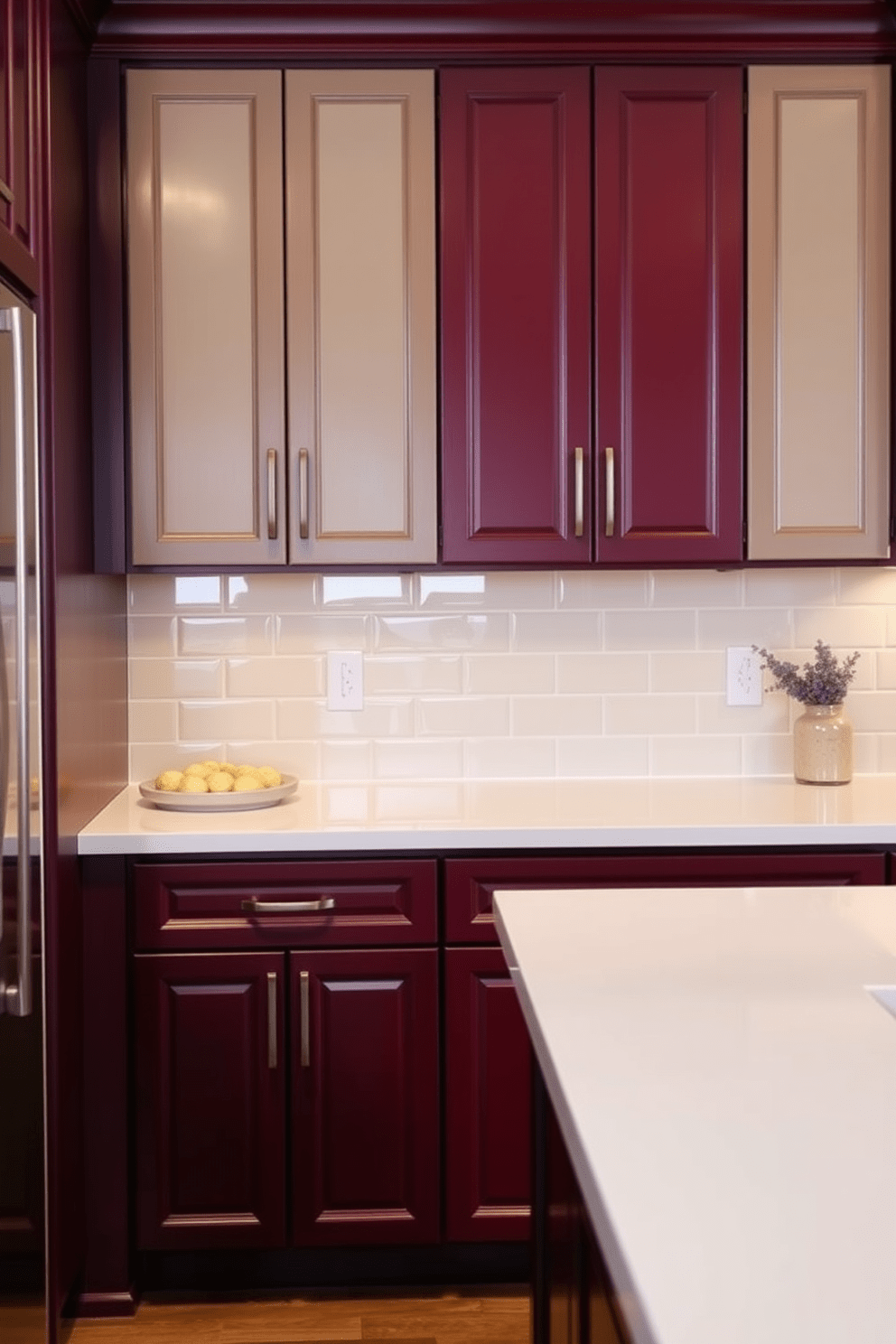 A two tone kitchen design featuring rich burgundy cabinetry paired with light beige upper cabinets. The countertops are a sleek white quartz, and the backsplash showcases a glossy subway tile in a matching beige tone.