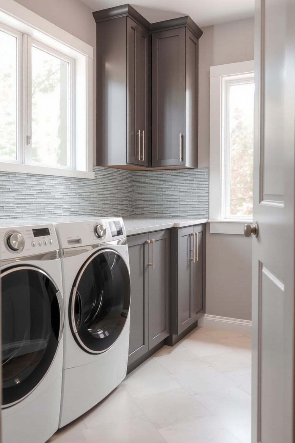 A stylish utility room featuring a textured backsplash that adds visual interest and depth to the space. The laundry room is combined with functional storage solutions, showcasing sleek cabinetry and a modern washer and dryer setup. Natural light floods the room through a large window, illuminating the unique tile design of the backsplash. The color palette consists of soft grays and whites, creating a clean and inviting atmosphere perfect for laundry tasks.