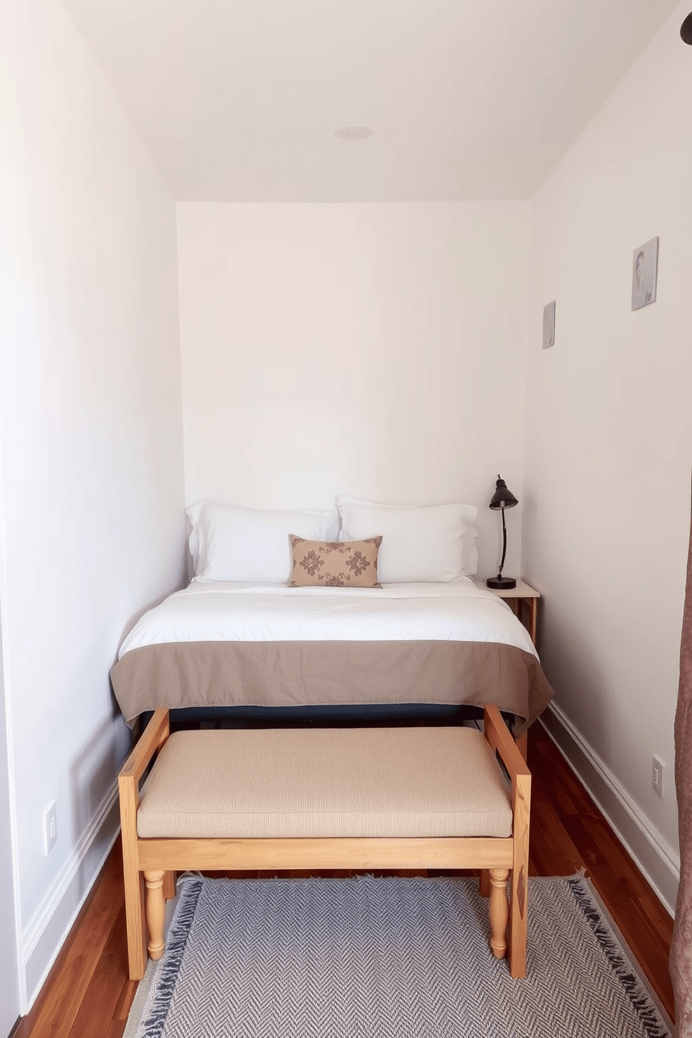 A very small bedroom featuring a cozy bed against the wall with soft linens and decorative pillows. At the foot of the bed, a small wooden bench provides additional seating and a place for storage. The walls are painted in a light, airy color to enhance the sense of space. A compact nightstand with a stylish lamp sits beside the bed, and a small rug adds warmth to the floor.