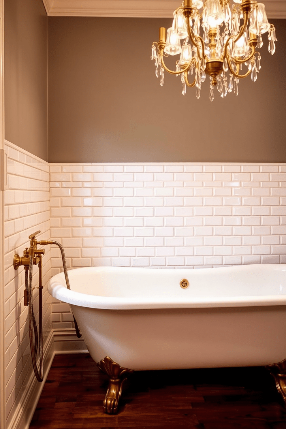 Classic clawfoot tub with vintage fixtures. The tub is positioned against a wall adorned with intricate white subway tiles, creating a timeless backdrop. Brass faucets and a handheld shower attachment complement the vintage aesthetic. Soft, ambient lighting from a chandelier above enhances the warm tones of the wooden floor.