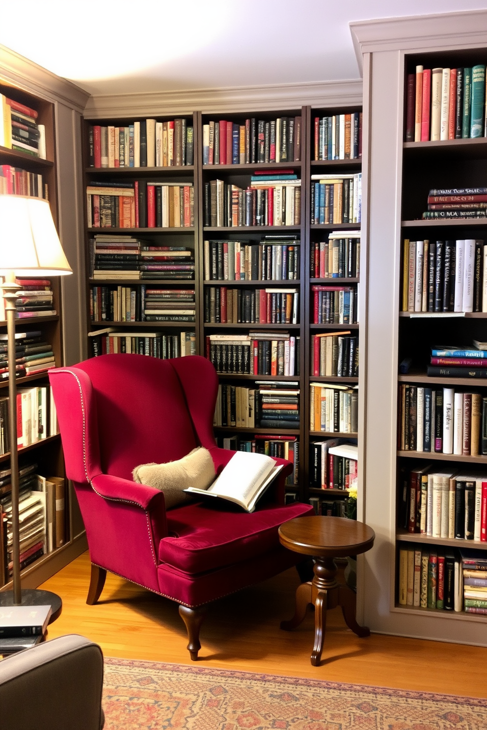 Cozy reading nook with a vintage armchair. The nook features a plush armchair upholstered in rich burgundy fabric, positioned next to a small wooden side table. Surrounding the nook are tall bookshelves filled with a diverse collection of books. Soft, warm lighting from a nearby floor lamp creates an inviting atmosphere perfect for reading.